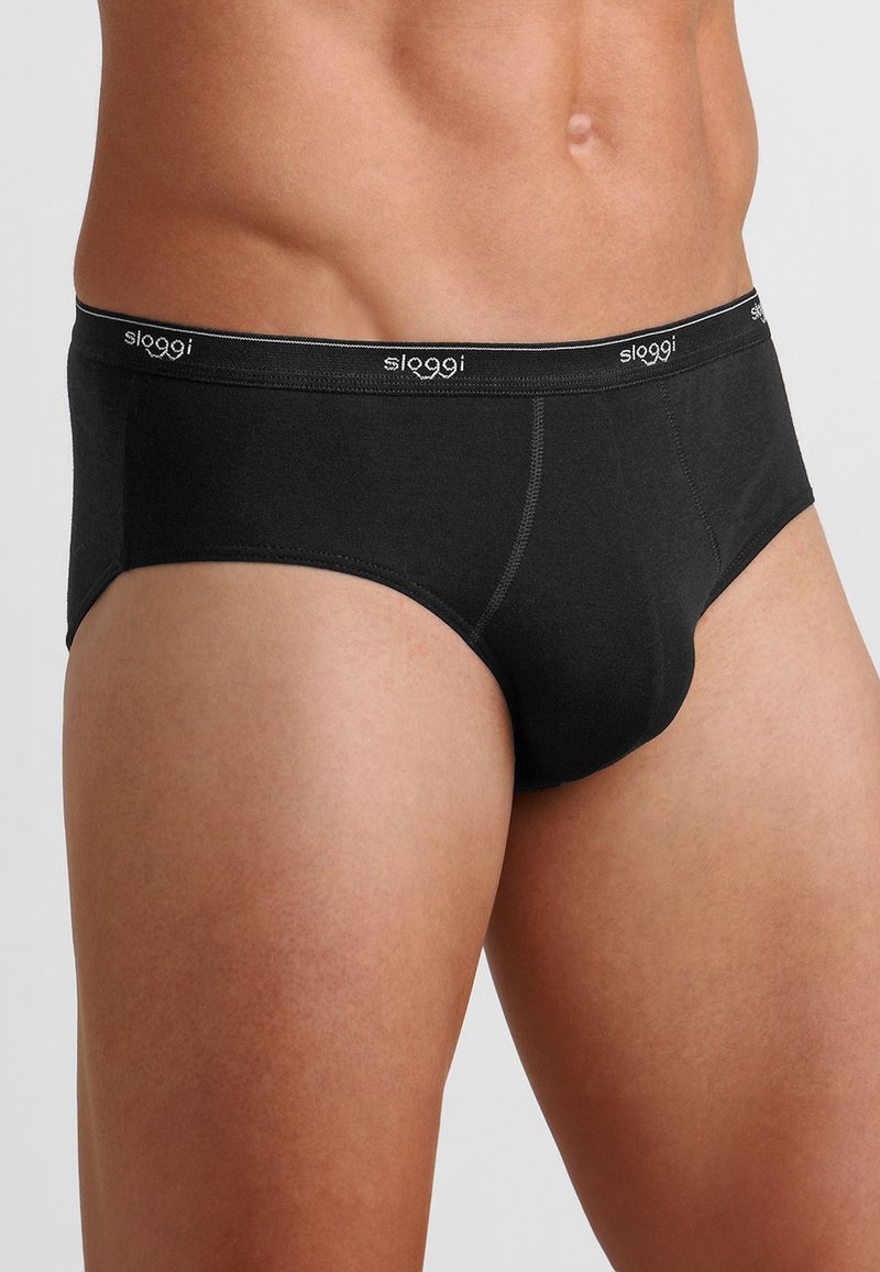 Slip Sloggi neri da uomo con una vestibilità aderente, cintura elastica con logo del marchio, texture liscia e design classico.