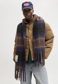 Gezellige, lange wollen sjaal met horizontale strepen in donkerblauw, grijs en bruin. Franje randen en een klein label detail onderaan.