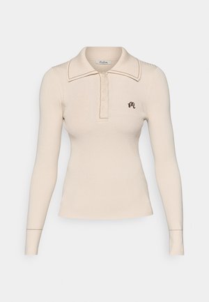 Ribbet langermet polo-skjorte i lys beige med krage, knappeplacket og mørkebrunt brodert logo på brystet.