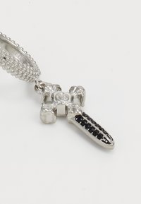 Zilveren kruis hanger met verfijnde details, voorzien van een gestructureerde band en versierd met zwarte edelstenen aan één arm.