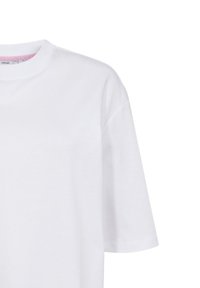 T-shirt blanc à manches courtes avec un col rond et une texture en coton lisse. Présente une étiquette de marque discrète à l'intérieur du col.