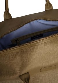 Borsa in pelle marrone con superficie testurizzata e fodera beige. Presenta una cerniera superiore e una tasca interna per l'organizzazione.