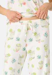 Vita, mjuk vävda loungebyxor med en färgglad tryck av cocktails, limeklyftor och kaktusar. Elastisk midja med snörning.