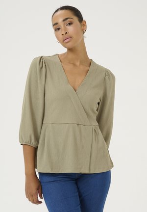 Olive green wrap blouse with a deep V-neck and three-quarter puff sleeves. The fabric has a subtle textured pattern. Tailored, peplum silhouette.
