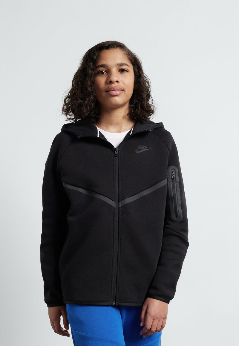Black zip-up hoodie with a textured feel, featuring a curved gray stripe across the chest and a zippered pocket on the left arm.