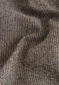 Textile fabric featuring a checkered pattern in brown, grey, and white tones, displaying a smooth texture and soft drape.