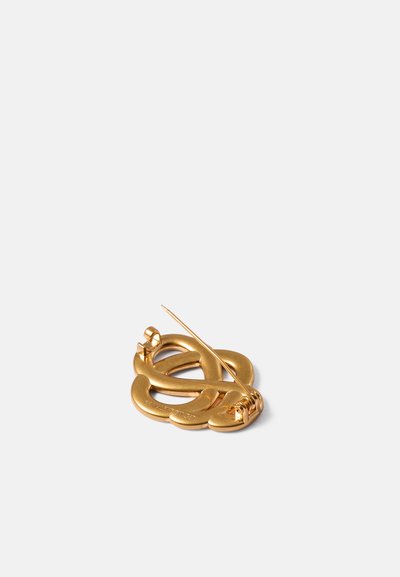 Broche de ouro com um design entrelaçado e uma textura suave e brilhante. Um alfinete pontiagudo se estende da parte de trás para uma fixação segura.