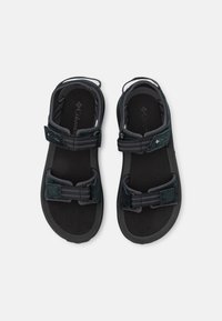Czarne sandały na zewnątrz z regulowanymi paskami, gładką teksturowaną wkładką i trwałą gumową podeszwą. Z logo na wkładce.