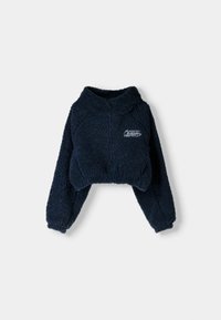 Marinblå kort sweatshirt i pluffsigt, texturerat tyg. Har en hög krage och lösa ärmar, med en liten broderad logotyp på bröstet.