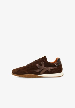 Scarpa da ginnastica in camoscio marrone con dettagli in pelle scura, linguetta posteriore decorata, suola in gomma e intersuola bianca, mostrata di profilo su sfondo bianco.