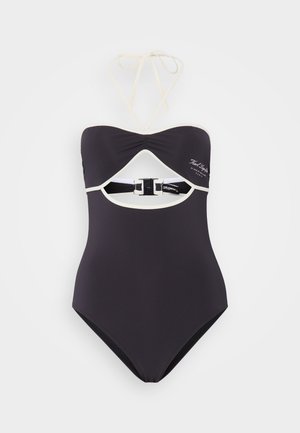 Svart baddräkt med halterneck, cut-out-design och beige detaljer; har en baksidespänne och ribbad textur.