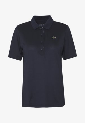Polo di colore blu navy realizzato in cotone. Presenta un colletto classico, una chiusura con tre bottoni e un piccolo logo verde ricamato sul petto.