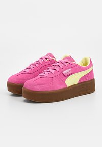 Baskets Puma Palermo en daim rose avec bande logo beige, semelle plateforme marron et lacets roses, présentées en angle sur fond blanc.