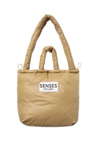 Tan padded tote bag with dual long straps, featuring a rectangular shape and a logo label on the front. Smooth, quilted texture.
