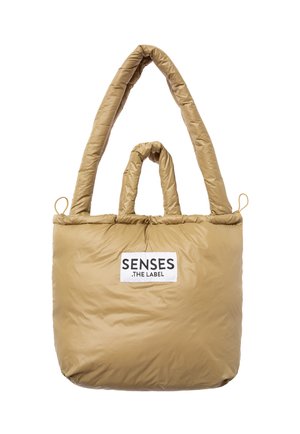 Beige gesteppte Tragetasche mit zwei langen Griffen, rechteckiger Form und einem Logoetikett auf der Vorderseite. Glatte, gesteppte Textur.