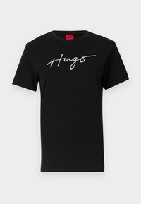 Black cotton t-shirt with short sleeves and round neckline. Features "Hugs" in cursive, printed in a reflective light color across the chest.