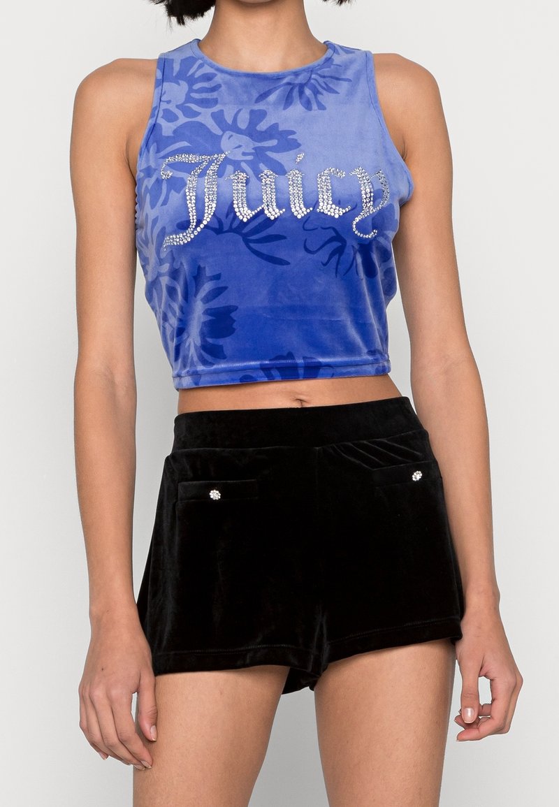 Modrý sametový crop top s květinovou texturou, zdobený trsy rhinestone se nápisem "Juicy". V páru s černými sametovými šortkami s dekorativními kapsami.
