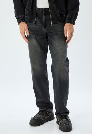 Zwarte denim jeans met een relaxte pasvorm, met een vervaagde textuur en een recht model. Gepaard met chunky zwarte sneakers.