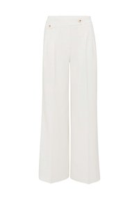 Pantalons larges en tissu blanc avec une finition texturée, présentant un devant plat, deux poches avant et des accents de boutons dorés.