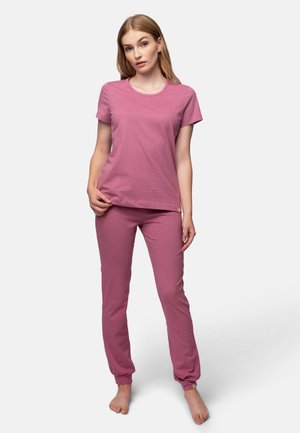 T-shirt in cotone rosa con maniche corte e scollo rotondo, abbinato a pantaloni rosa coordinati con polsini elastici e una piccola etichetta con logo.