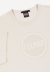 Beiges Colmar Originals T-Shirt mit regulärem Schnitt-Etikett und dezentem rundem Logo auf der Brust gedruckt.