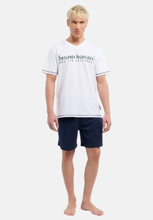 Weißes Baumwoll-T-Shirt mit blauem Grafiktext, V-Ausschnitt und kontrastierenden Details; kombiniert mit marineblauen Shorts, die alle eine lockere Passform haben.