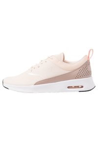 Nike Air Max sneakers in light pink and beige, featuring a mesh upper, smooth accents, perforated detailing, and a white sole with air cushioning.