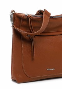 Braune Lederhandtasche mit strukturiertem Finish, silbernem Zubehör, einem Reißverschluss und einem verstellbaren Tragegurt. Verfügt über eine Fronttasche mit genähten Details.