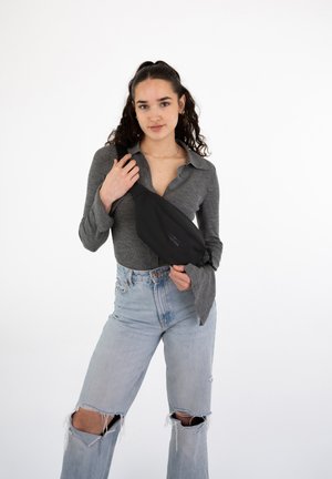 Marsupio nero in nylon con tracolla regolabile. Caratterizzato da una texture liscia e un design elegante, posizionato su uno sfondo bianco semplice.