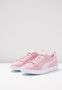 Rosa mockalädersneakers med en vit gummisole, snördesign och ett kontrasterande sidosträck med Puma-logotypen.