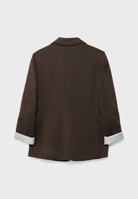 Blazer marron à manches longues avec poignets rayés blancs retournés, dos droit et col cranté sur fond gris clair.