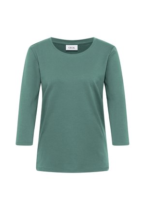 T-shirt en coton vert doux avec des manches 3/4 et un col rond. Design simple sans motifs ni accents visibles. Étiquette de la marque : CECIL.