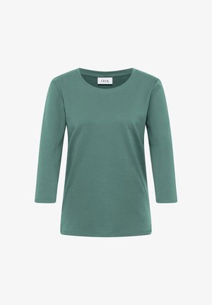 T-shirt en coton vert doux avec des manches 3/4 et un col rond. Design simple sans motifs ni accents visibles. Étiquette de la marque : CECIL.