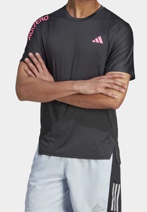 Černé sportovní tričko s krátkými rukávy, kulatým výstřihem a růžovými akcenty loga Adidas. Vyrobeno z lehké, prodyšné tkaniny.