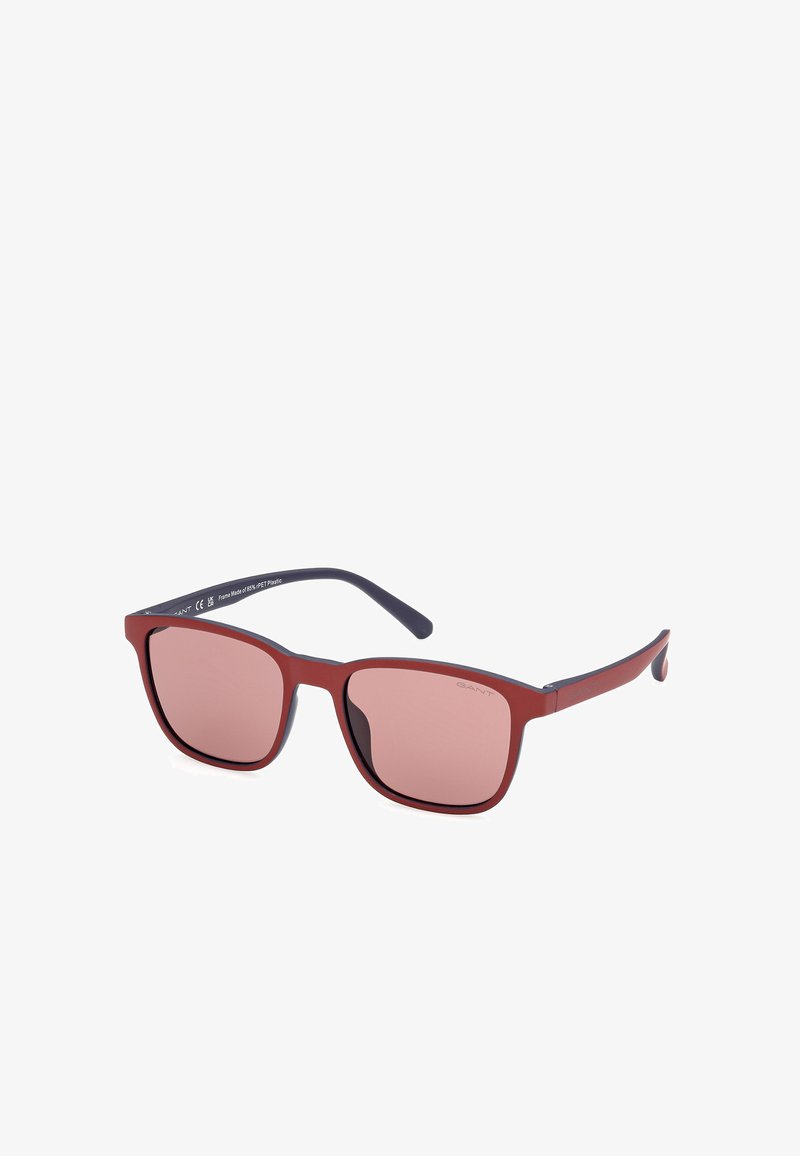 Gafas de sol con un marco rectangular de plástico rojo mate, con lentes pink degradados y patillas oscuras sólidas, marcadas con el nombre de la marca.