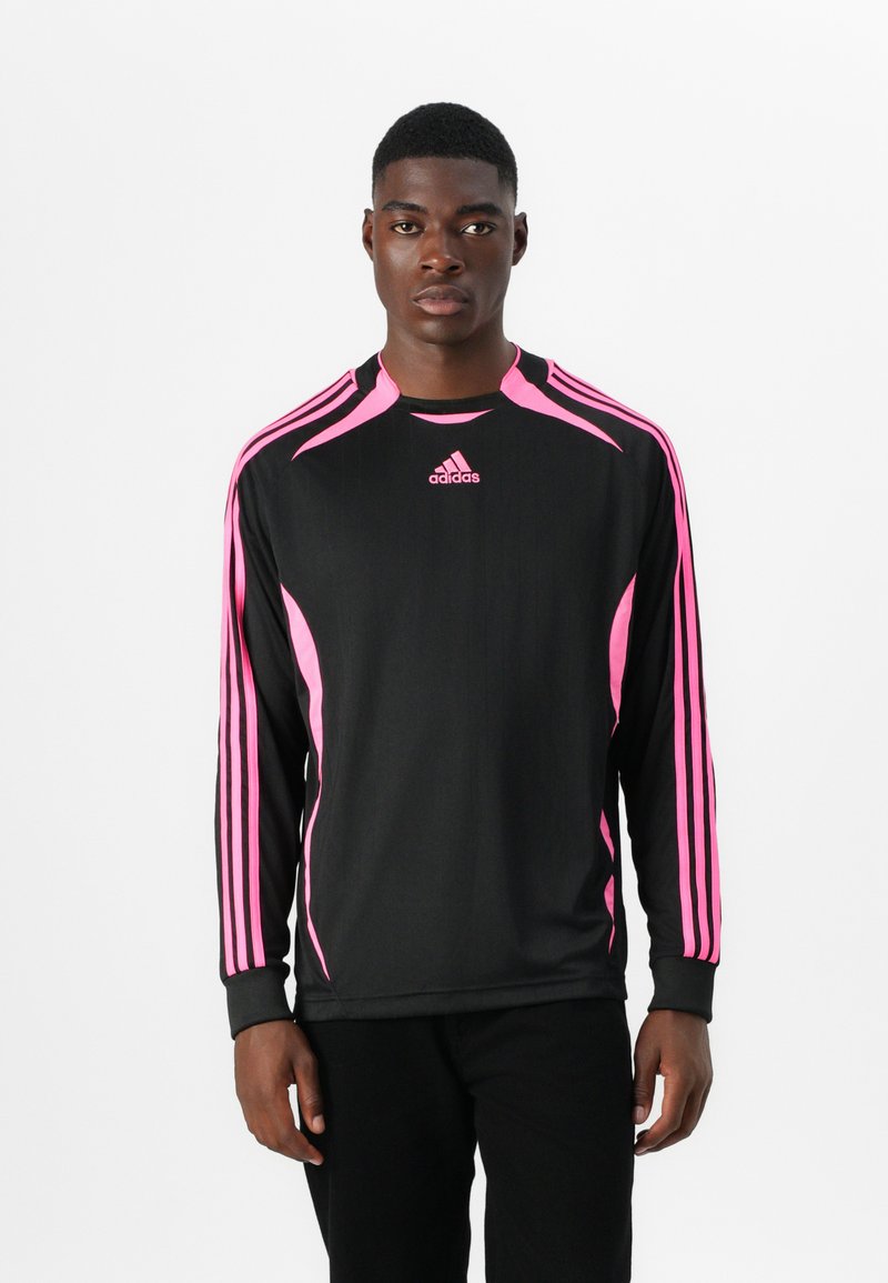 Juoda ilgomis rankovėmis sportinė marškinė su rožinėmis detalėmis ir trimis rožinėmis juostelėmis peties ir rankovėse. Krūtinėje yra Adidas logotipas.