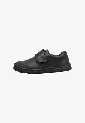 Zapato de cuero negro con punta redondeada, correa de Velcro ajustable y suela de goma texturizada para mayor agarre. Presenta detalles cosidos a lo largo de los bordes.