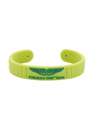 Žuta silikonska narukvica s ugraviranim logotipom Aston Martin i tekstom "FORMULA ONE™ TEAM", s teksturiranim unutarnjim dijelovima i segmentima.