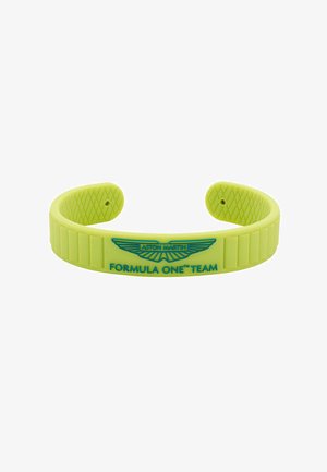 Bracelet manchette en silicone jaune avec logo Aston Martin en relief et texte "FORMULA ONE™ TEAM", avec intérieur texturé et sections.
