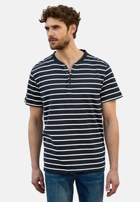 Sininen ja valkoinen raidoitettu lyhythihainen paita, jossa on henley-tyylinen kaula-aukko ja kolme nappia; valmistettu pehmeästä, kevyestä kankaasta.