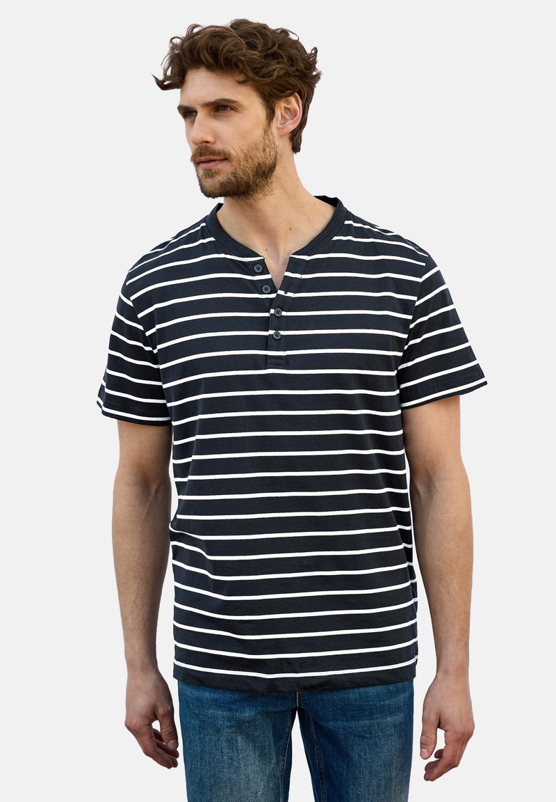 Sininen ja valkoinen raidoitettu lyhythihainen paita, jossa on henley-tyylinen kaula-aukko ja kolme nappia; valmistettu pehmeästä, kevyestä kankaasta.