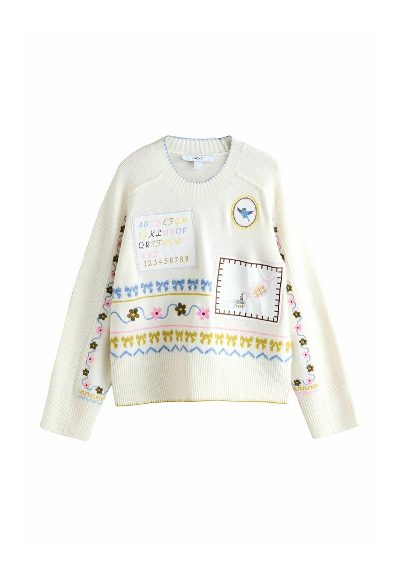 Witte gebreide trui met kleurrijke borduursels van het alfabet, cijfers, bloemenpatronen en een decoratieve zak. Ronde hals en geribbelde manchetten.