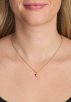 Colier cu ton auriu, cu un lanț delicat și un pandantiv texturat în formă de inimă. Pandantivul are o suprafață strălucitoare.