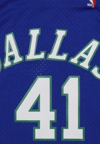 La camiseta deportiva azul presenta "DALLAS" en blanco con ribetes verdes, encima del número "41" en blanco, sobre una tela de malla transpirable.