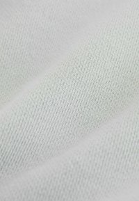 Lysegråt strikket stof med en glat tekstur, der har et fint ribmønster og en diskret glans. Ideel til tøj eller polstringsformål.