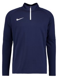 Marinblå sportig långärmad topp med hög krage och vit dragkedja. Har Nike-logotypen på vänster bröst, tillverkad av mjukt och stretchigt material.