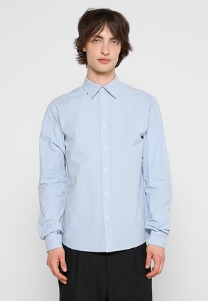 Camicia a maniche lunghe azzurro chiaro con colletto a punta, chiusura con bottoni e ricamo del logo discreto. Tessuto di cotone liscio.