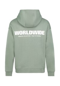 Hellgrüner Kapuzenpulli mit Kapuze, auf der Rückseite mit fettem weißen Text: "WELTWEITE SUBLEVEL-KOLLEKTION - BLEIB DIR SELBST TREU." Einfaches Design.