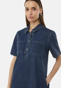 Dunkles Denim-Hemdkleid mit Kragen, kurzen Ärmeln und zwei vorderen Taschen. Verfügt über eine Knopfleiste und Kontrastnähte.