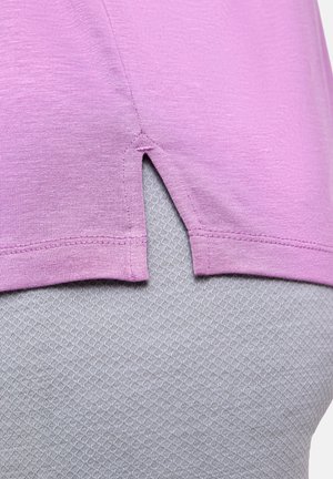 Paarse, lichtgewicht stoffen blouse met een zijsplitdetail, gedragen over een gestructureerd grijs kledingstuk met een diamantpatroon.